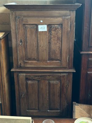 une grande armoire en bois avec un bol de nourriture posé par terre