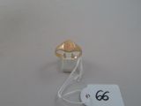 a gold ring on a white table with a price tag