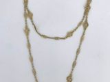 a close up of a necklace on a white surface