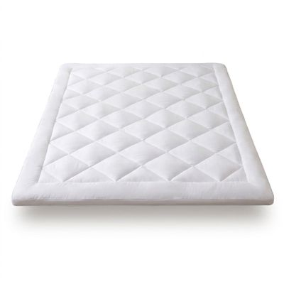 Le surmatelas est en coton blanc et est doté d'une housse matelassée