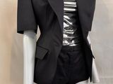 a mannequin dressed mannequin wearing a black jacket and skirt