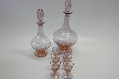 des bouteilles et des verres sont alignés sur une surface blanche
