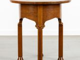 une petite table ronde avec un plateau et des pieds en bois