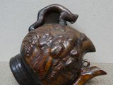 un vase marron muni d'une anse et orné d'un chat