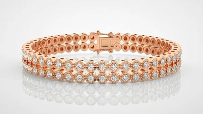 a rose gold bracelet with diamonds on a white background
