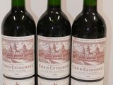 three bottles of red wine are lined up on a table
