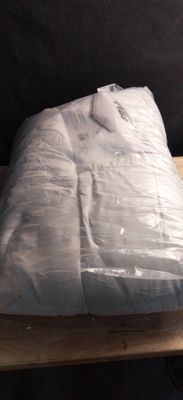 a mattress that is wrapped in plastic on a wooden table