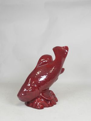 a red bird figurine sitting on top of a white table