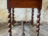 a small table with a wooden top on a brick floor