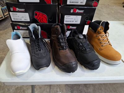 Plusieurs paires de chaussures sont alignées sur une table dans un magasin.