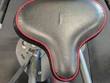 a black and red exercise bike with a red seat