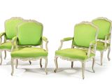 pair of green upholstered chairs with carved arms and arms