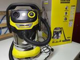 un aspirateur jaune et noir posé sur une table, à côté d'une boîte
