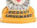 a close up of a toy of a clown on a stand