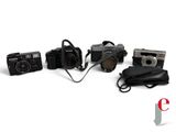 four cameras and a bag on a white surface