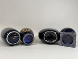 three black vases with gold designs on them sitting next to each other