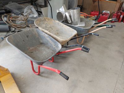 two wheelbarrows that are sitting in a garage