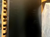 a black computer monitor sitting on top of a wooden table