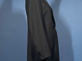 a black coat on a mannequin stand against a blue background