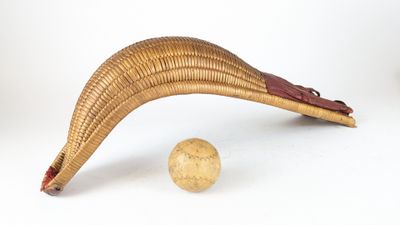 une banane posée à côté d'un ballon sur une surface blanche