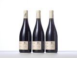 three bottles of wine are lined up on a table
