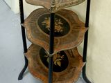 a three tiered table with a clock on top of it