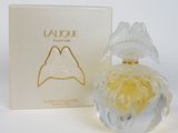 a bottle of perfume sitting next to a box on a white surface