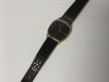 a black and gold watch on a white surface