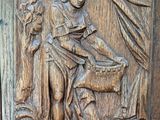 relief of a woman with a basket in her hand on a wooden panel