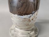 a white vase with a brown and black design on it