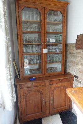 un meuble en bois avec des portes en verre dans le coin d'une pièce