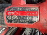 a close up of a red drill with a black handle