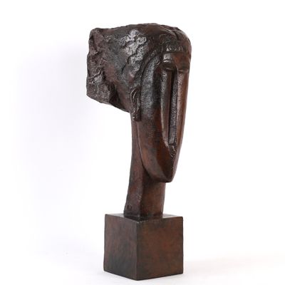 une photo d'une sculpture représentant une tête posée sur un socle en bois