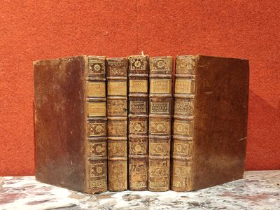 trois vieux livres sont empilés sur une table