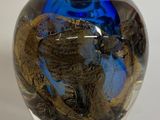 un vase en verre bleu orné d'un motif représentant un dragon