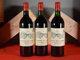 three bottles of red wine sitting next to each other on a table