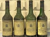 quatre bouteilles de vin sont alignées sur une table