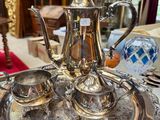 a silver tea set on a silver tray on a table