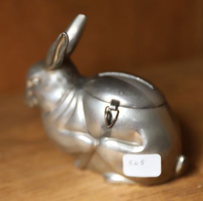 une figurine de lapin en argent posée sur une table en bois