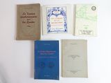 plusieurs livres sont alignés sur une table à fond blanc