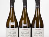 trois bouteilles de vin posées les unes à côté des autres sur une surface blanche