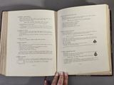 a person holding a book open on a table
