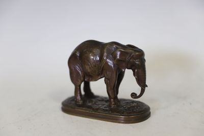 statue d'un éléphant debout sur un socle posé sur une surface blanche