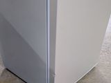a white refrigerator sitting on the floor in a kitchen