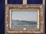 une peinture à l'huile représentant un paysage, posée sur un chevalet en bois, avec un fond bleu