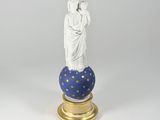 a statue of a woman holding a child on top of a globe