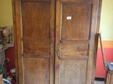a large wooden armoire in the corner of a room