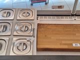 Plusieurs plateaux de nourriture sont posés sur un comptoir devant une porte vitrée