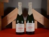 two bottles of champagne sitting next to each other on a table