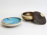 a small bowl with a lid sitting next to a smaller bowl